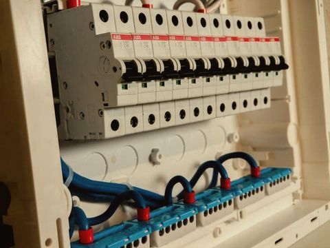 A row of circuit breakers and safety switches in an open switchboard